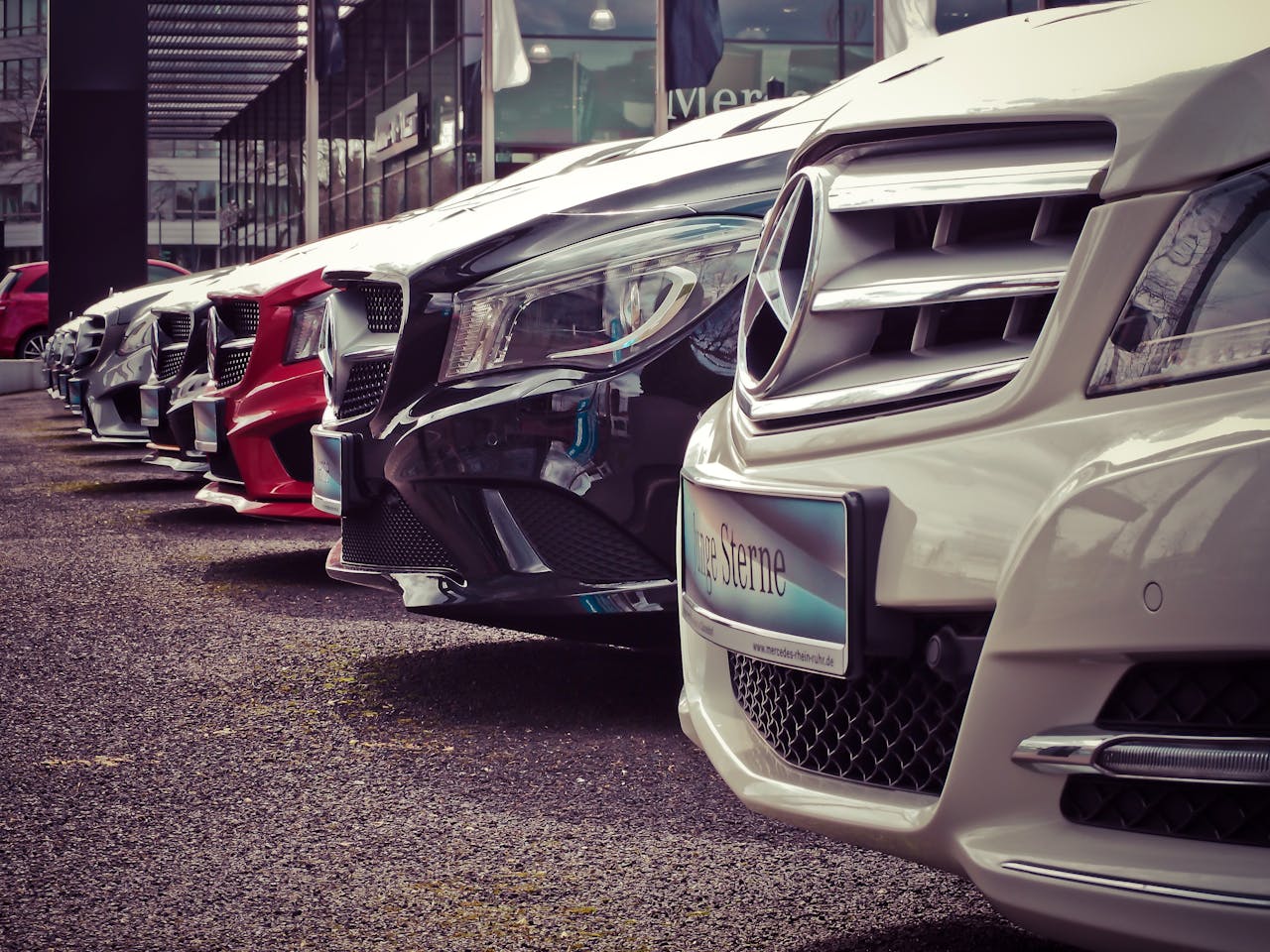 our-story Luxury cars lined up at an outdoor dealership, showcasing sleek designs.