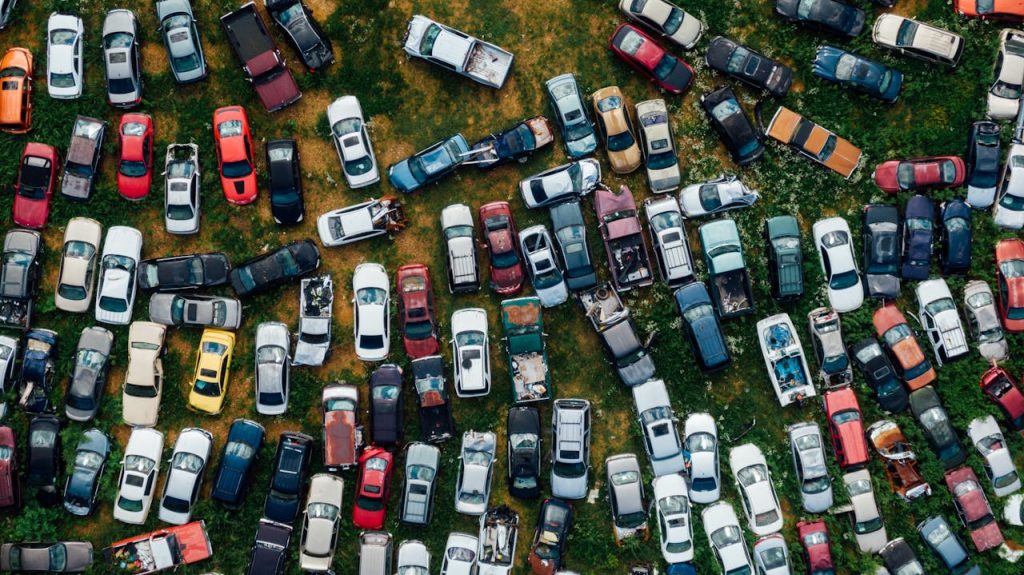 A top-down view of vibrant, abandoned cars in a scrapyard, showcasing urban decay.